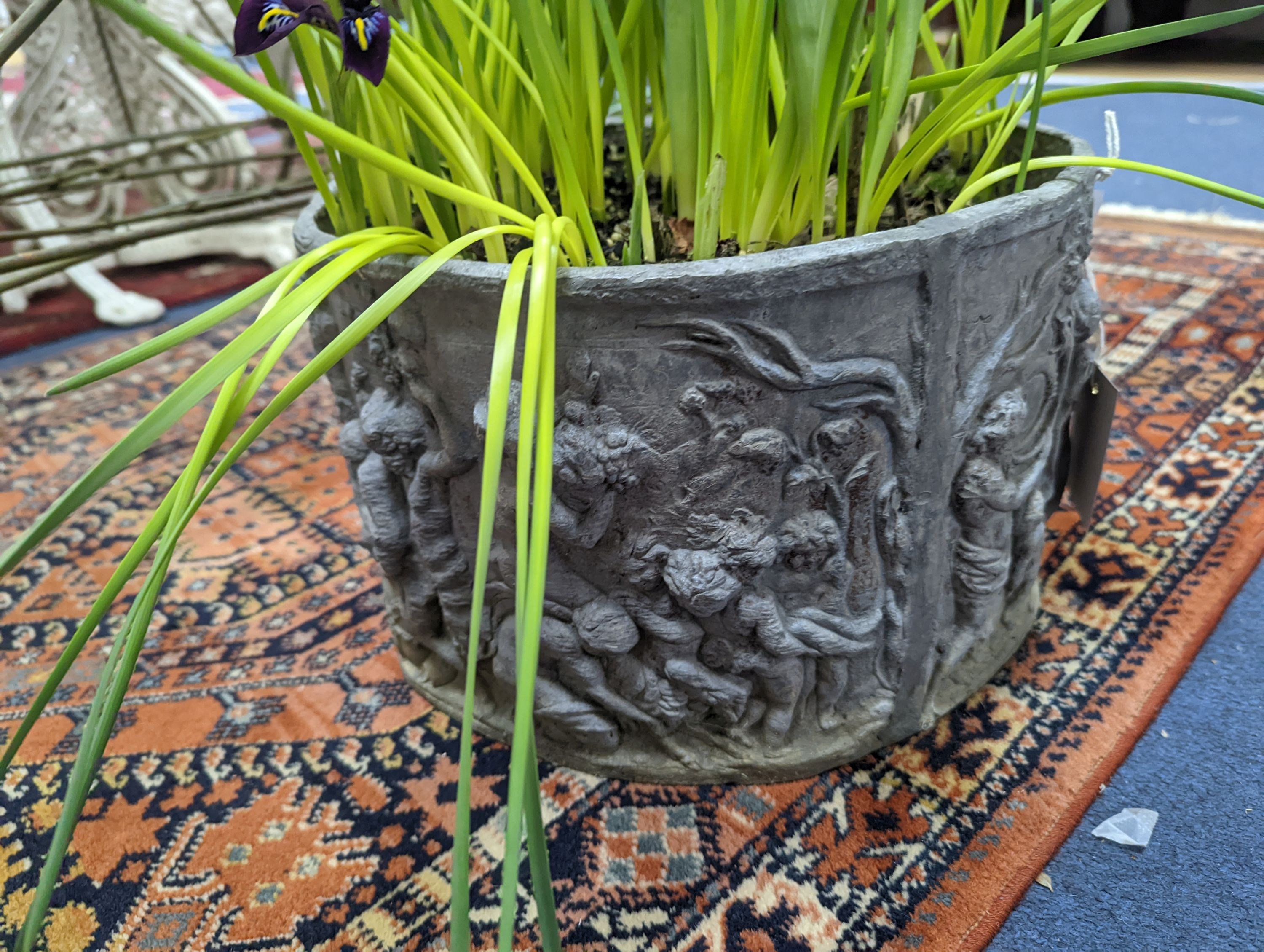 A circular lead planter moulded with Bacchic putti, diameter 30cm